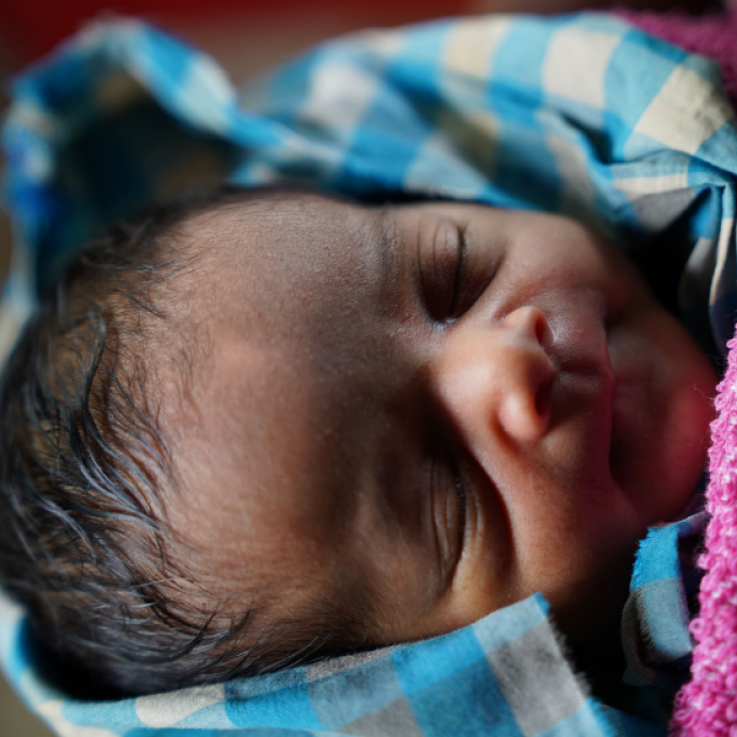 Neonato che dorme avvolto in coperte calde.